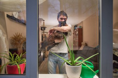 Kedili adam evde kalır, enfeksiyonu önlemek için kendini izole eder..