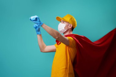 Kurye süper kahraman maskesi ve koruyucu yüz maskesi takıyor..