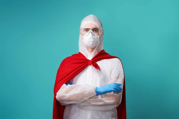 El médico está usando PPE - traje, guantes y mascarilla quirúrgica en capa de superhéroe . —  Fotos de Stock