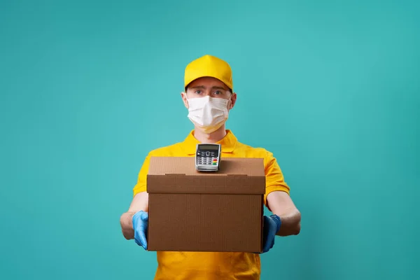 Kurýr s lékařskou maskou na tváři drží krabici a připínáček. — Stock fotografie