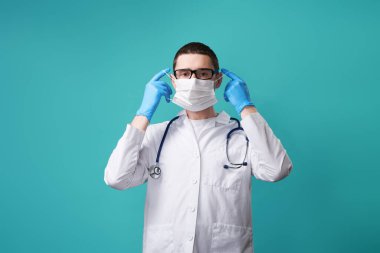 Steteskoplu doktor koruyucu tıbbi maske takıyor..