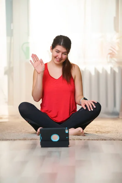 Frau sitzt auf dem Boden und plaudert per Tablet — Stockfoto