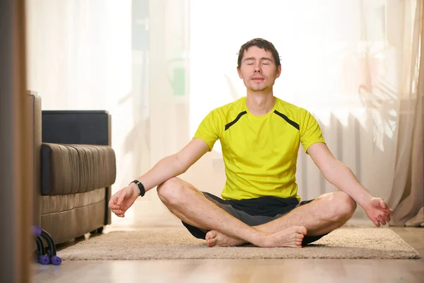 Frau praktiziert Yoga und meditiert zu Hause in Lotusposition. — Stockfoto