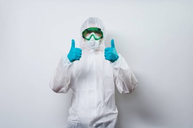 Doktor PPE giyiyor - kostüm, eldivenler ve süper kahraman pelerinli cerrahi maske.