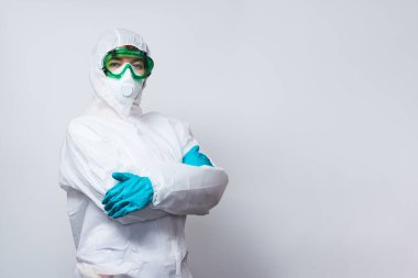 Doktor PPE giyiyor. Kostüm, eldiven ve cerrahi maske..