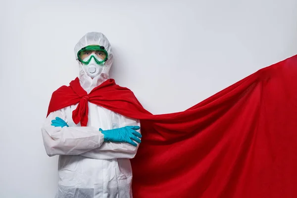 Dokter mengenakan PPE kostum, sarung tangan dan masker wajah bedah di jubah superhero. — Stok Foto