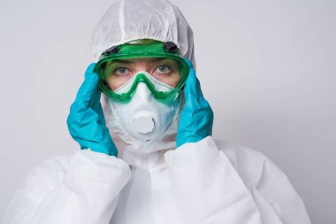 Doktor PPE giyiyor. Kostüm, eldiven ve cerrahi maske..