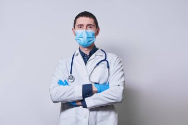 Doktor ameliyat maskesi ve eldiven takıyor..