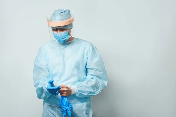 Doktor ameliyat maskesi ve eldiven takıyor..