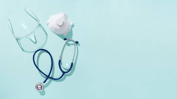 Фонендоскоп, респиратор и защитные очки на синем фоне
.
