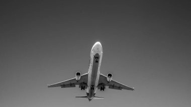 Siyah ve beyaz uçak önümüzde uçuyor.