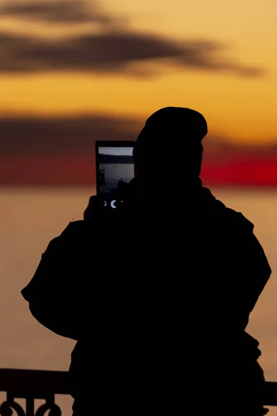 Mann Mit Hut Fotografiert Den Sonnenuntergang Auf Seinem Tablet — Stockfoto