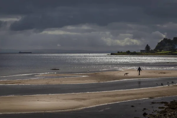 Kumsalda ve güneş ışığında Arran 'daki Whiting Bay' de