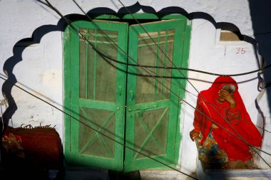 Kırmızılı kadın yeşil kapıda.