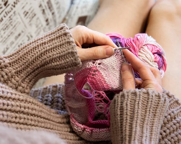 Knitting on knitting. Hands close-up knitting on knitting needles.