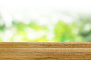 Yeşil bokeh arkaplanındaki ahşap masa