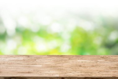 Yeşil bokeh arkaplanda açık kahverengi ahşap masa