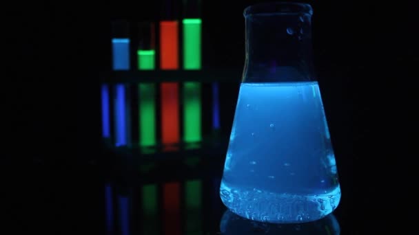 Productos químicos líquidos brillantes en tubos de ensayo médicos y frasco . — Vídeos de Stock