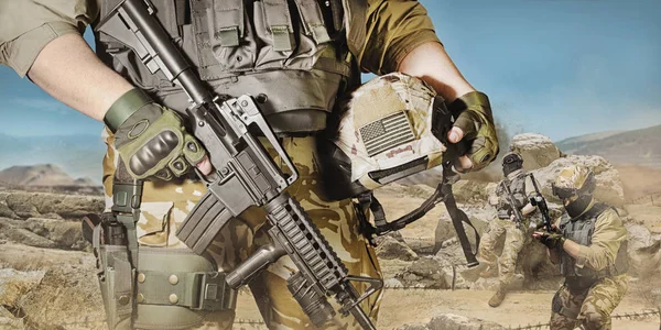 一个装备精良的士兵在沙漠战场背景上摆枪和步枪的照片 — 图库照片