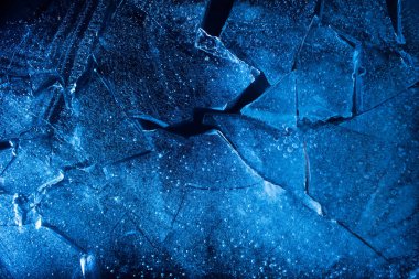 Photo texture of a broken blue lightened and toned ice with cracks. clipart