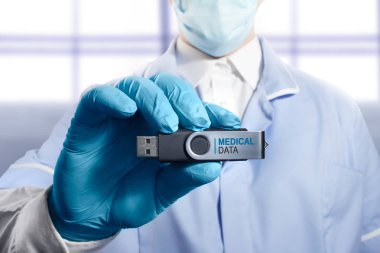 Bir doktorun tam kıyafeti bir usb flash tıbbi veri ile tutarak fotoğraf.