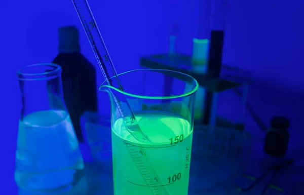 Лабораторні Пляшки Світяться Неоновими Хімікатами Стоять Скляному Столі — стокове фото