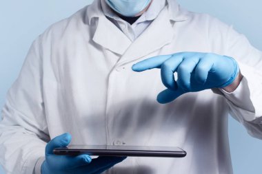 Laboratuar asistanı tutarak ve tablet vasıl işaret tıbbi kıyafetiyle fotoğrafı.