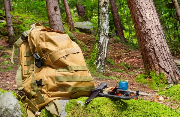 Mochila tática com lanterna e faca que coloca no roc floresta — Fotografia de Stock