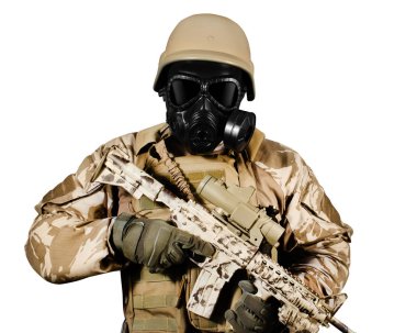 Üniformalı ve gaz maskeli bir asker tüfekle dikiliyor..