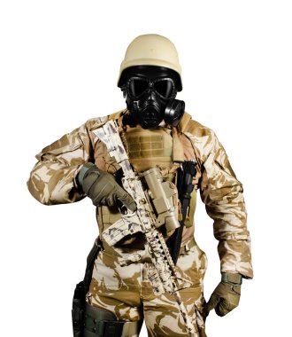 Üniformalı ve gaz maskeli bir asker tüfekle dikiliyor..