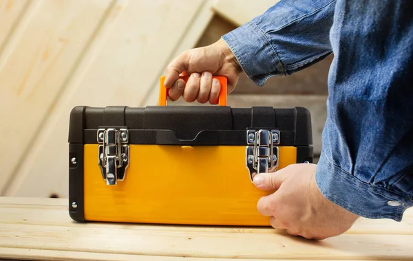 Worker in shirt closing yellow toolbox. — Stock Photo, Image