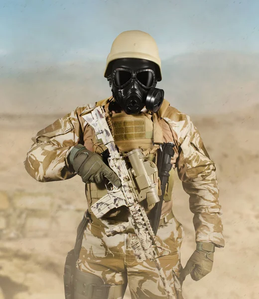 Soldat în uniformă și masca de gaz în picioare cu pușcă în deșert . — Fotografie, imagine de stoc