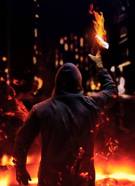Maskeli ve kapüşonlu bir protestanın fotoğrafı. Gece sokaklarında yanan molotof kokteylinin yükselişi..