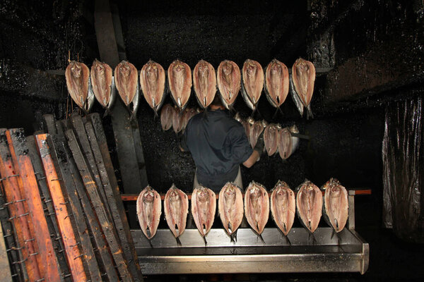 A kipper is a whole herring, a small, oily fish, that has been split in a butterfly fashion from tail to head along the dorsal ridge, gutted, salted or pickled, and cold-smoked over smouldering woodchips.