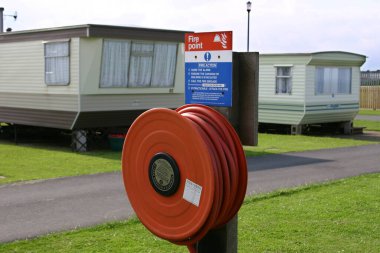 Büyük statik karavan tatil parkında halk için yangın hortumu ve uyarı uyarısı. Yorkshire 'ın doğu kıyısında. İngiltere.