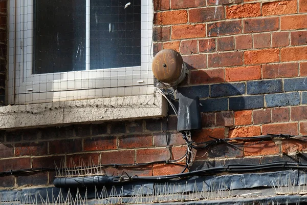 Corroding alarm bell for long defunct burglar alarm system on old building.