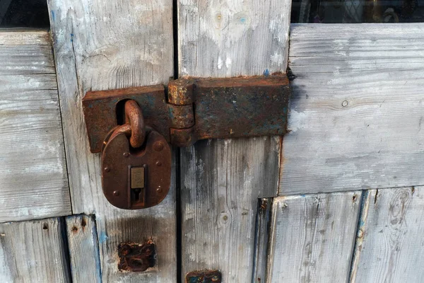 Old padlock and hasp on a farm gate to prevent access and egress without permission.