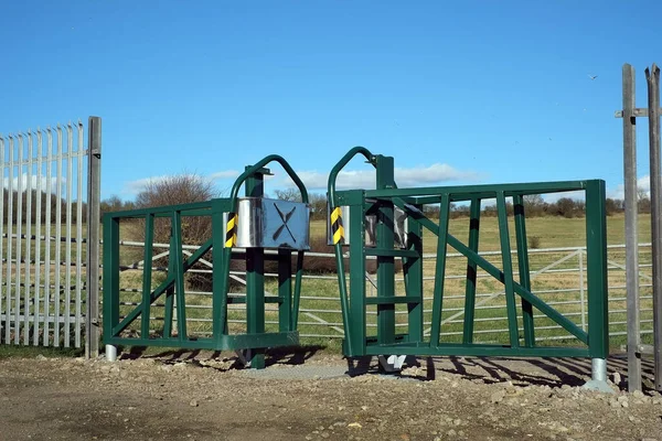 Modern high security steel safety gate on farmland track to stop wheeled vehicles.