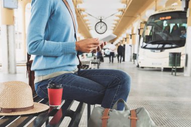 İstasyonda tablet kullanan genç bir kadın