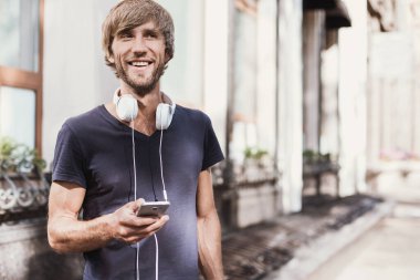 Genç adam akıllı telefon kullanıyor. 