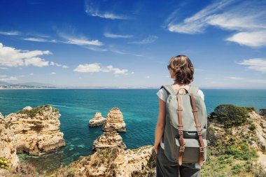 Portekiz 'in Algarve bölgesindeki Lagos kasabası yakınlarındaki körfeze bakan kadın turist