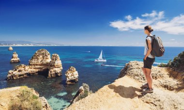 Portekiz 'in Algarve bölgesindeki Lagos kasabası yakınlarındaki körfeze bakan kadın turist