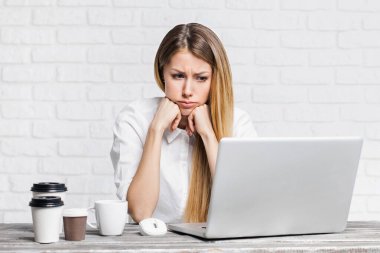 Genç, güzel, üzgün iş kadını ofiste çalışıyor. 