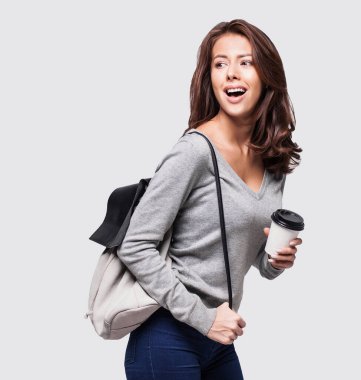 Sırt çantalı, elinde kahve olan güzel bir kadın. 