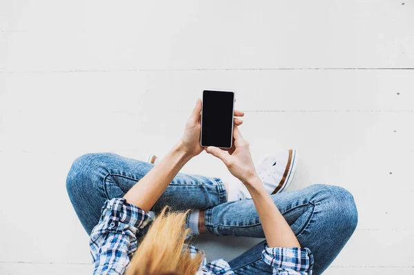 Νεαρή Όμορφη Γυναίκα Κάθεται Στο Πάτωμα Και Χρησιμοποιώντας Smartphone — Φωτογραφία Αρχείου