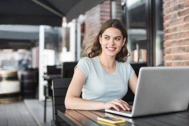 Kafede dizüstü bilgisayar kullanan güzel bir kadın. 