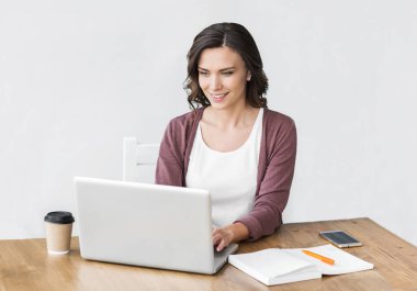 Ofiste bilgisayar kullanan genç ve güzel bir kadın.