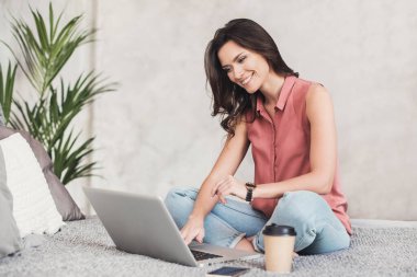 Evde bilgisayar kullanan güzel bir kadın.