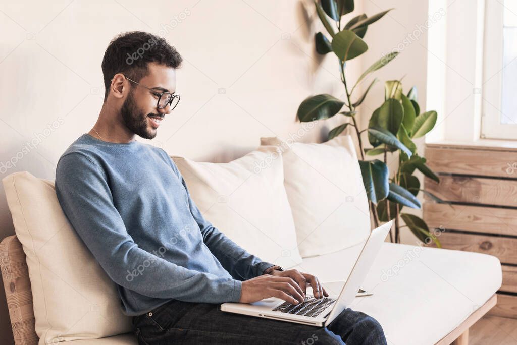 Handsome young man using laptop computer at home, businessman warking in his room, home work or study, freelance, distance education concept