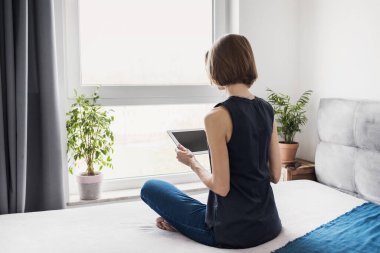 Tablet bilgisayar kullanan güzel bir kadın.